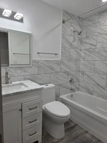a bathroom with a granite countertop toilet sink and mirror