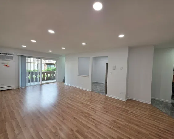a view of empty room with wooden floor and fireplace