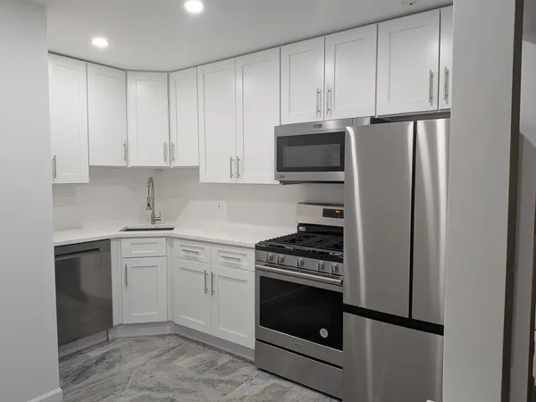 a kitchen with cabinets stainless steel appliances and a sink