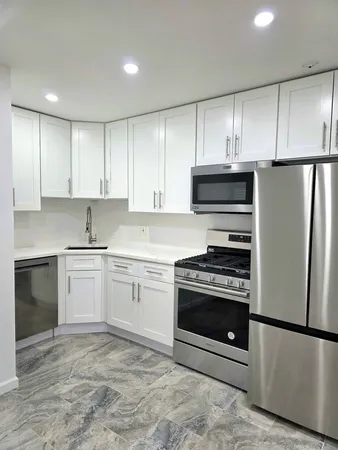 a kitchen with cabinets stainless steel appliances and a counter space