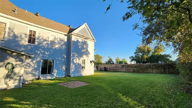 a view of a big house with a big yard and large trees