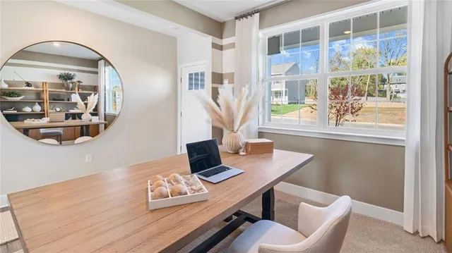 a view of a workspace with furniture and a window