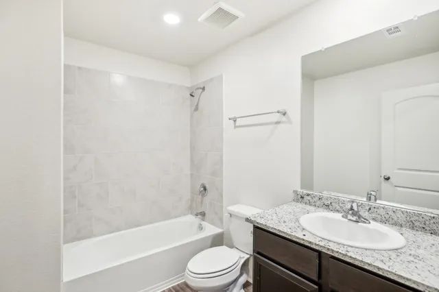 a bathroom with a granite countertop sink toilet tub and shower