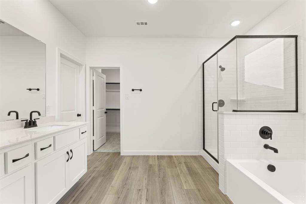1821 Bachman Lane Forney, TX 75126 - Photo 19 of 27 a bathroom with a double vanity sink a mirror a bathtub and shower