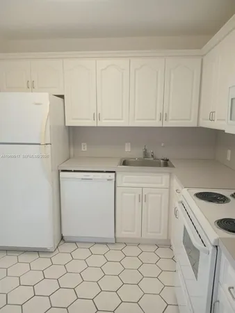 a kitchen with white cabinets and white appliances