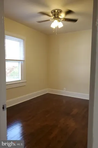 an empty room with a window and a ceiling fan