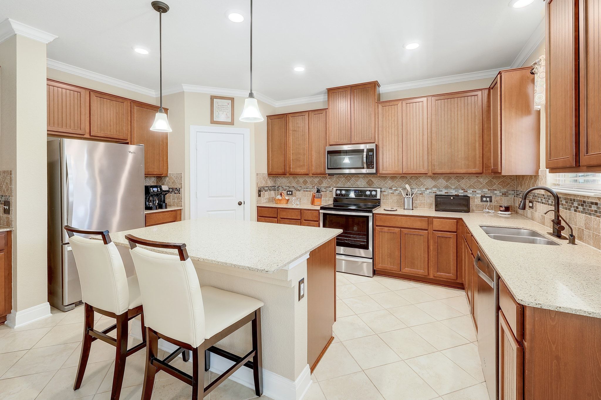 a kitchen with stainless steel appliances granite countertop a sink a stove a refrigerator cabinets a dining table and chairs