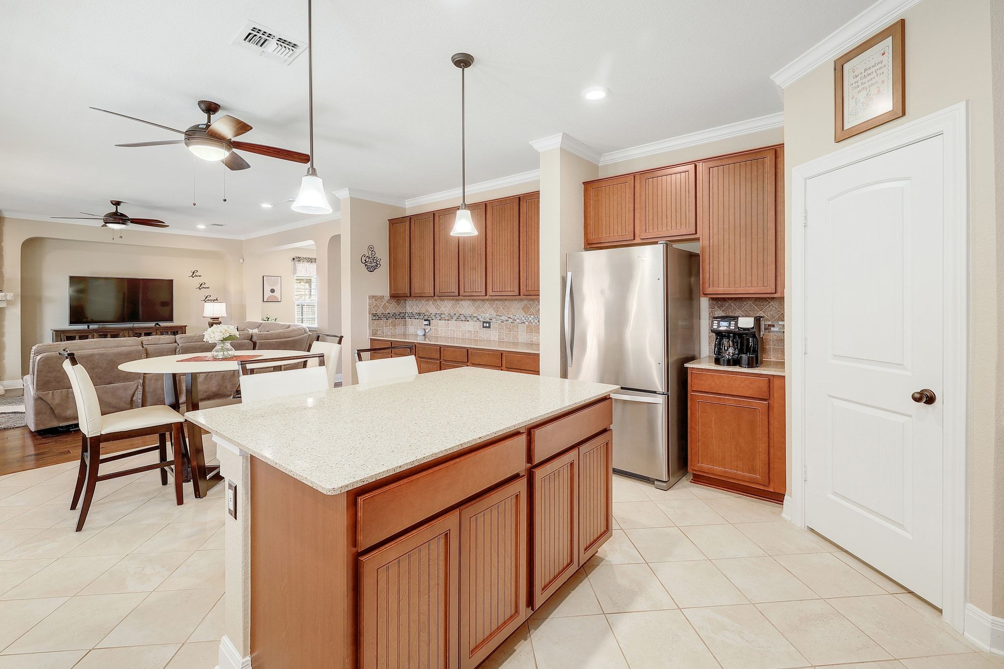 646 Landon Samuel Loop Pflugerville, TX 78660 - Photo 13 of 40 a kitchen with stainless steel appliances kitchen island granite countertop a refrigerator a stove top oven a sink a dining table and chairs with wooden floor