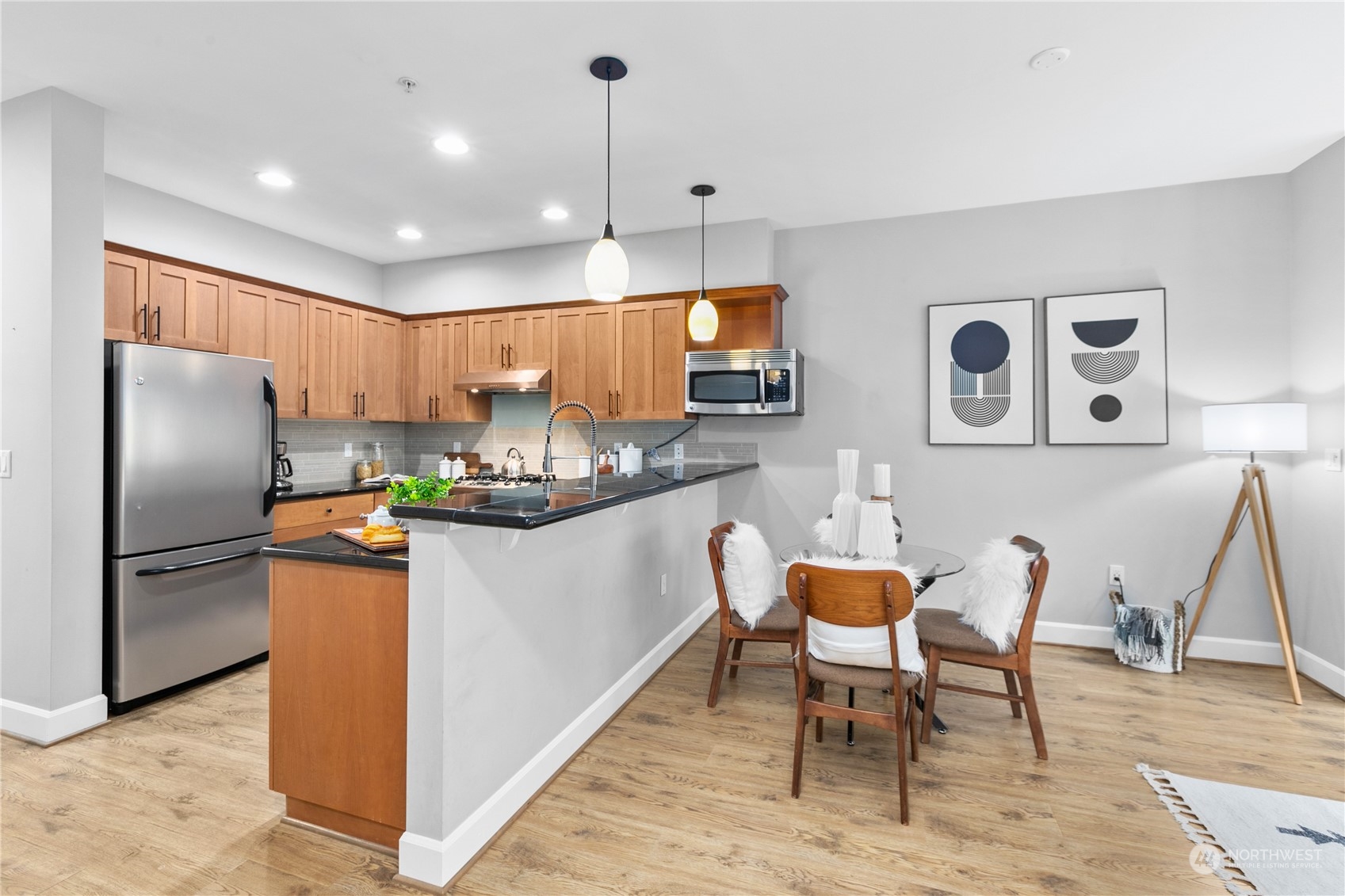 2115 201st Place Southeast, Unit D3 Bothell, WA 98012 - Photo 9 of 25 a kitchen with stainless steel appliances granite countertop a refrigerator a stove a sink a dining table and chairs with wooden floor