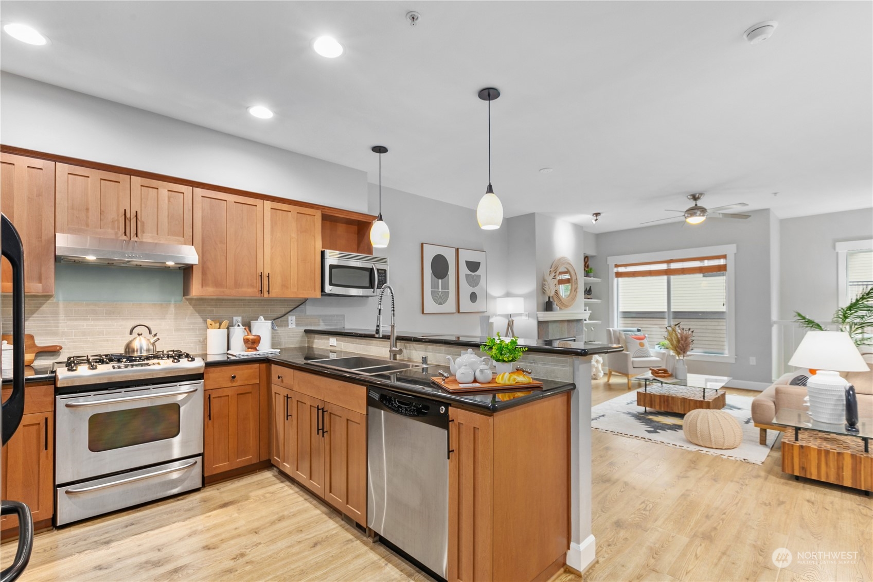 2115 201st Place Southeast, Unit D3 Bothell, WA 98012 - Photo 10 of 25 a kitchen with stainless steel appliances granite countertop a stove top oven a sink dishwasher a dining table and chairs with wooden floor