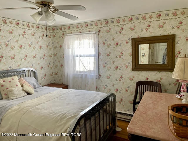 816 Atlantic Avenue, Unit A Point Pleasant, NJ 08742 - Photo 18 of 23 a bedroom with a bed and a chandelier