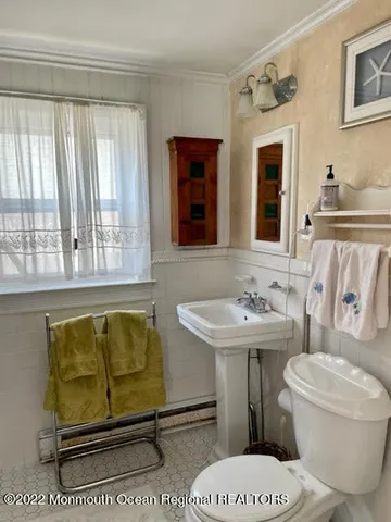 a bathroom with a sink toilet and window