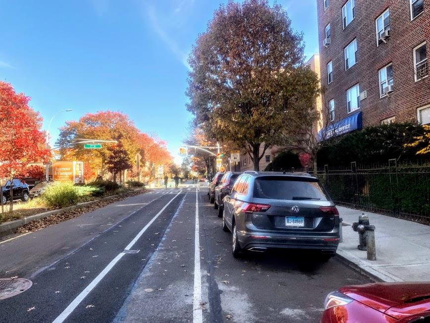 76-10 34th Avenue, Unit 2M Queens, NY 11372 - Photo 9 of 9 View of asphalt street featuring street lighting, sidewalks, and curbs