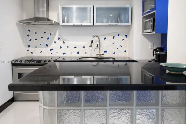 a kitchen with granite countertop a stove and cabinets