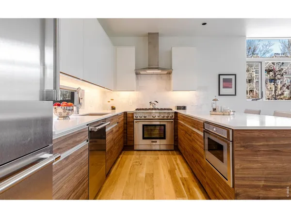 a kitchen with stainless steel appliances granite countertop a stove a sink and a refrigerator