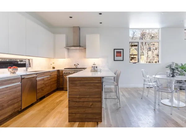 a kitchen with granite countertop a sink cabinets and wooden floor