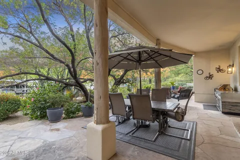 a view of a patio with couches table and chairs and potted plants