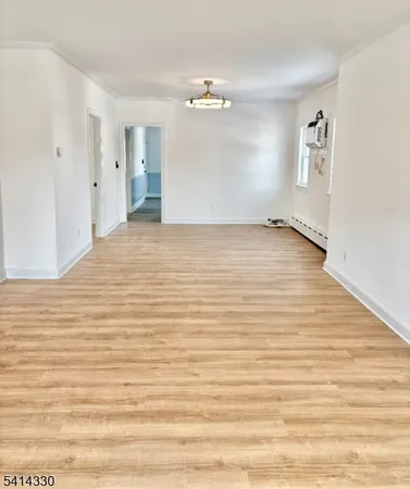 a view of a room with wooden floor and white walls