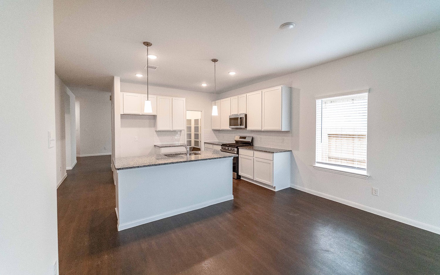 1718 Windrose Bend Angleton, TX 77515 - Photo 4 of 14 a kitchen with a refrigerator and white cabinets
