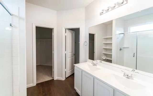 a bathroom with a double vanity sink mirror and shower