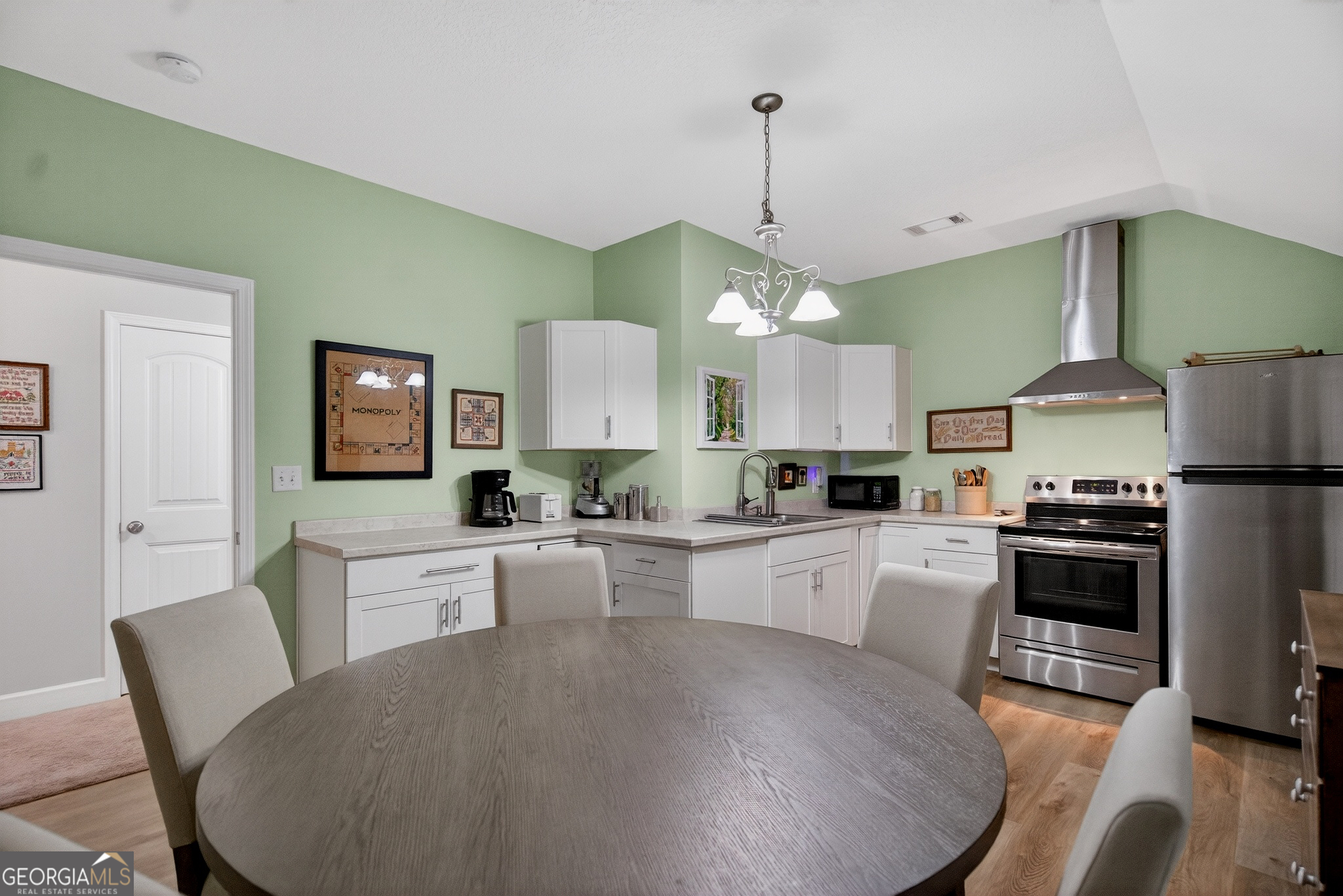 830 John Lovelace Road LaGrange, GA 30241 - Photo 36 of 44 a large kitchen with kitchen island a stove a sink a dining table and chairs