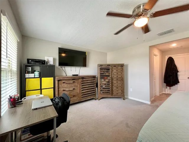 a bedroom with a large bed and flat tv screen on the dresser