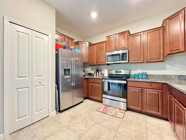 a kitchen with stainless steel appliances granite countertop a refrigerator and a stove top oven