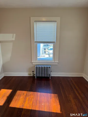 an empty room with wooden floor and a window