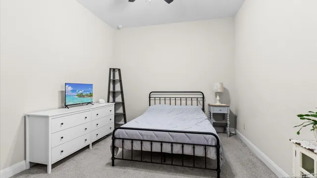 a bedroom with a bed and a potted plant on dresser