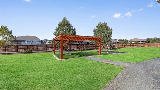 a view of a green field with house in the background
