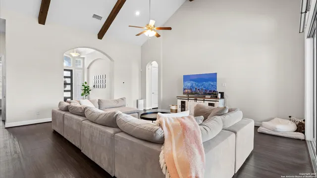 a kitchen with stainless steel appliances granite countertop a refrigerator a stove a sink dishwasher and a dining table with wooden floor