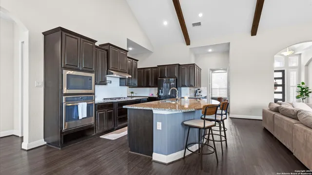 a kitchen with stainless steel appliances granite countertop a stove top oven a sink and dishwasher
