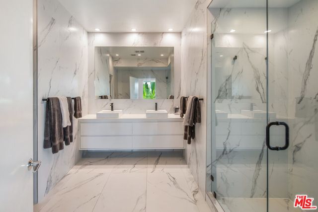 a bathroom with a double vanity sink mirror and shower
