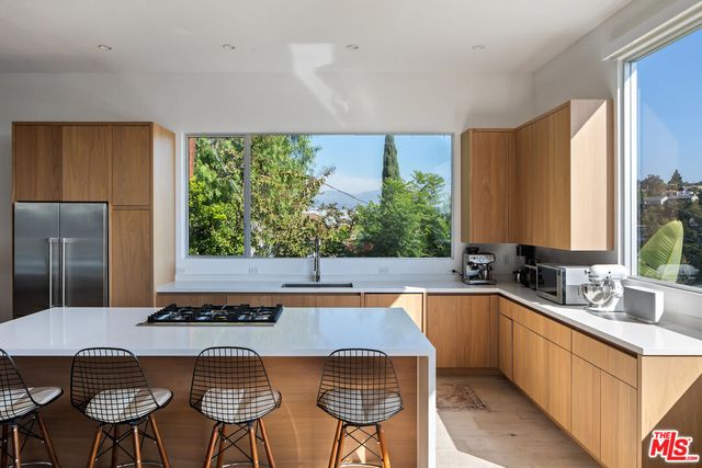 a kitchen with a table chairs sink and cabinets