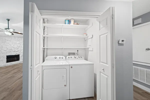 a view of washer and dryer with kitchen in the background