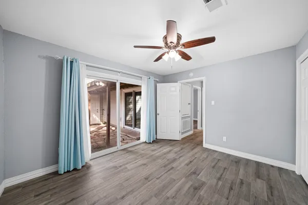 a view of a livingroom with wooden floor and a ceiling fan