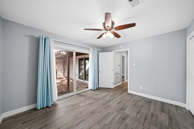 a view of a livingroom with wooden floor and a ceiling fan