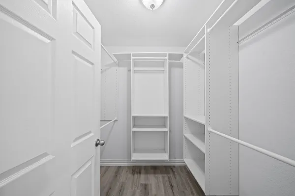 a view of walk in closet with empty racks