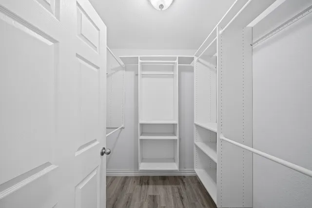 a view of walk in closet with empty racks