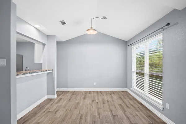 a view of a room with wooden floor and a window