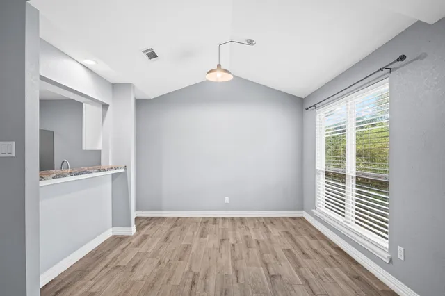 a view of a room with wooden floor and a window