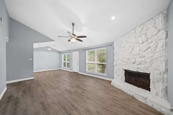 a view of empty room with wooden floor and fireplace