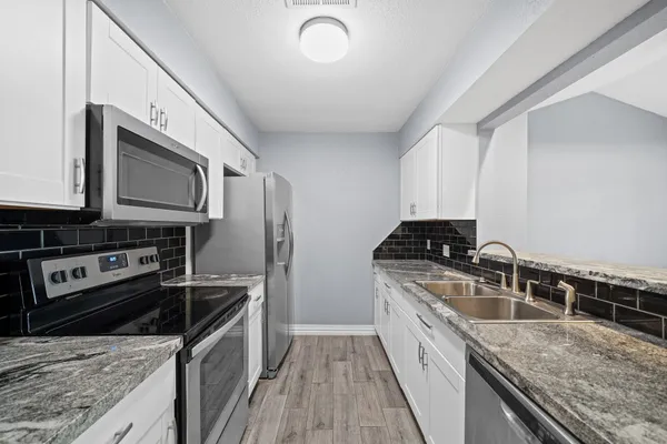 a kitchen with stainless steel appliances granite countertop a sink stove and refrigerator