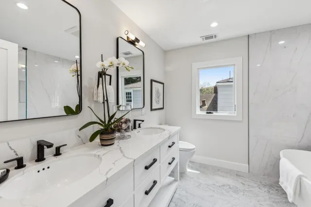 a bathroom with a tub a window and a shower