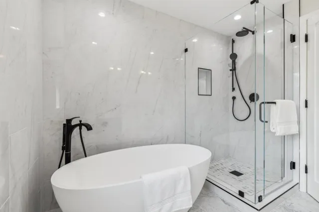 a bedroom with bed a mirror and a window