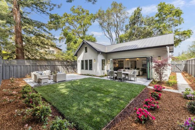 a view of a house with a yard and sitting area