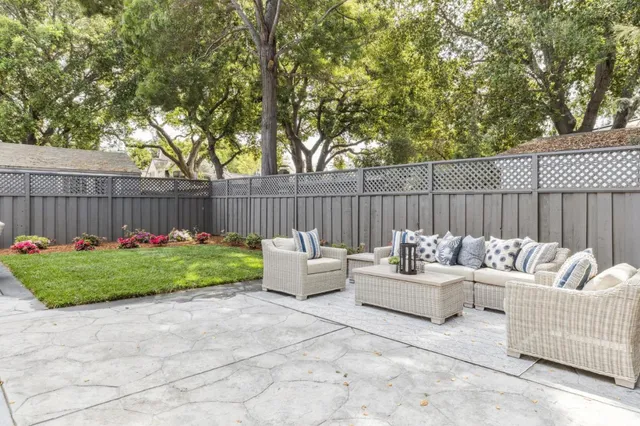 a view of a patio with table and chairs potted plants and a large tree