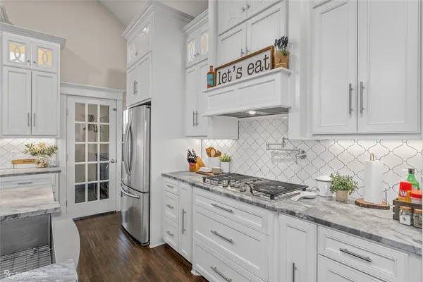 a kitchen with stainless steel appliances granite countertop a refrigerator and a stove