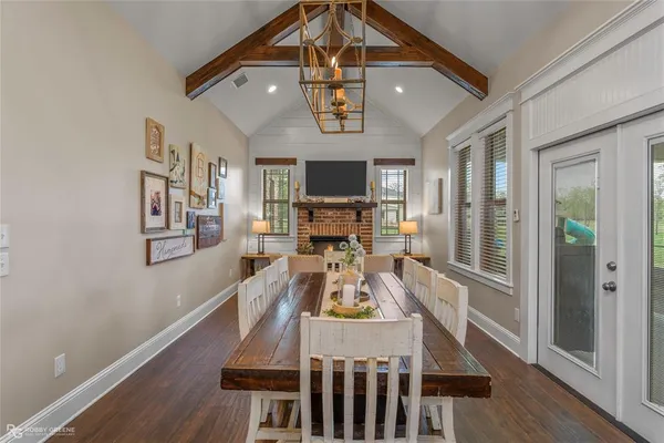a view of a dining room with furniture a chandelier and wooden floor