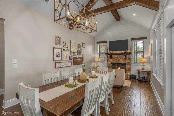 a view of a dining room with furniture a chandelier and wooden floor